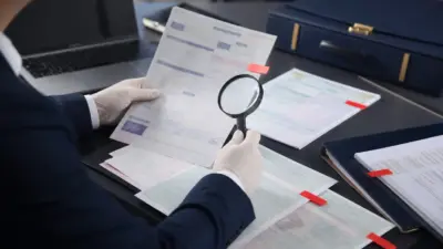 Petugas kepatuhan bank memeriksa dokumen kendaraan untuk mengantisipasi fraud dokumen melalui audit perbankan